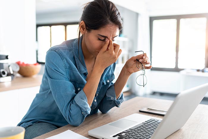 gestresste Geschäftsfrau, die von zu Hause aus arbeitet und Schwierigkeiten hat, ihren Geist zu entspannen