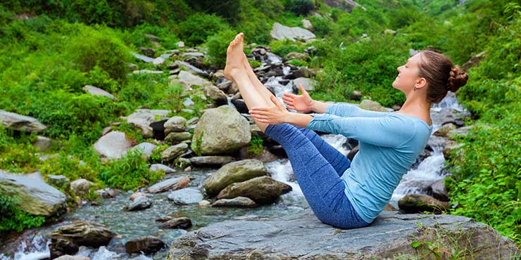 femeie care face ashtanga yoga poziția barca