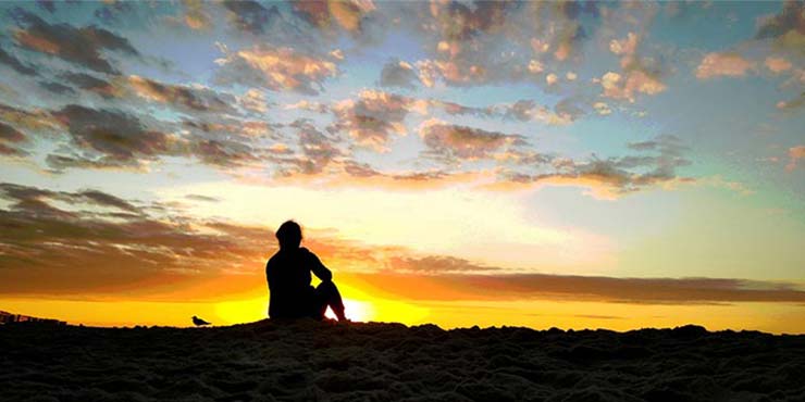 mulher praticando meditação matinal durante o nascer do sol