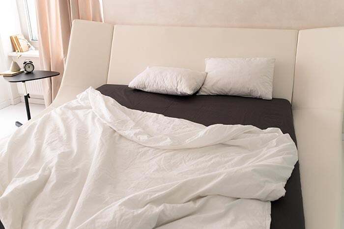 หมอนสีขาวสองใบวางอยู่บนเตียง