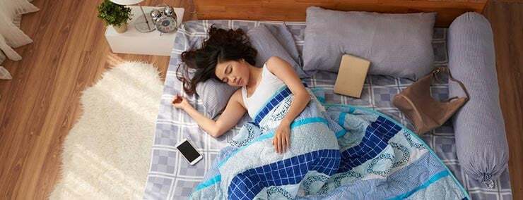 ผู้หญิงนอนหลับบนพื้น