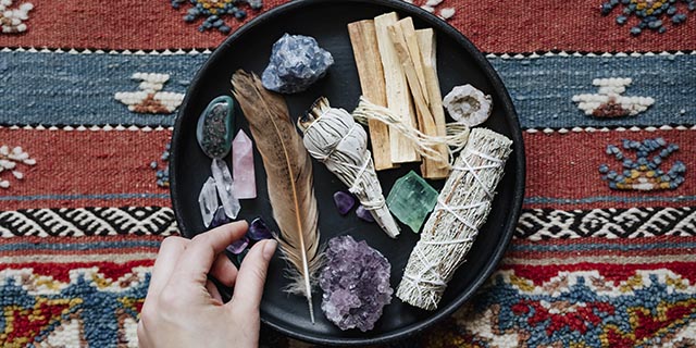 donna con salvia e cristalli pronta per lo smudging