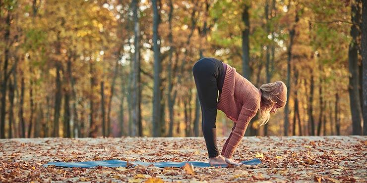 woman transitioning between uttanasana and Ardha Uttanasana