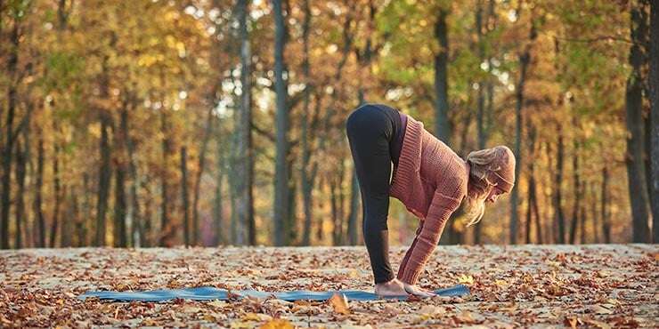 woman transitioning between uttanasana and Ardha Uttanasana