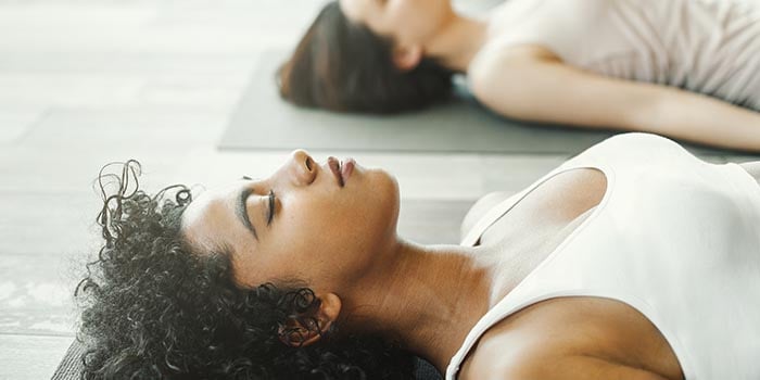 mujer haciendo la postura savasana en yoga nidra
