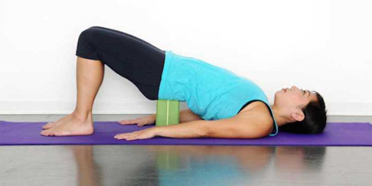 bridge pose with sacrum supported on yoga block