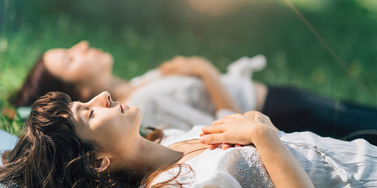two women practicing yoga nidra scripts outdoors